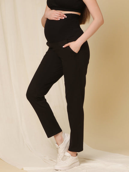 Side view of black maternity fleece pants with bump-hugging over-belly waistband and relaxed fit