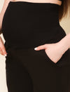 Close-up of over-the-belly maternity winter pants in black with adjustable waistband and side pocket