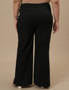 Plus-size woman in back view wearing Black Plus Size Bootcut Jeans with classic pockets and bootcut silhouette