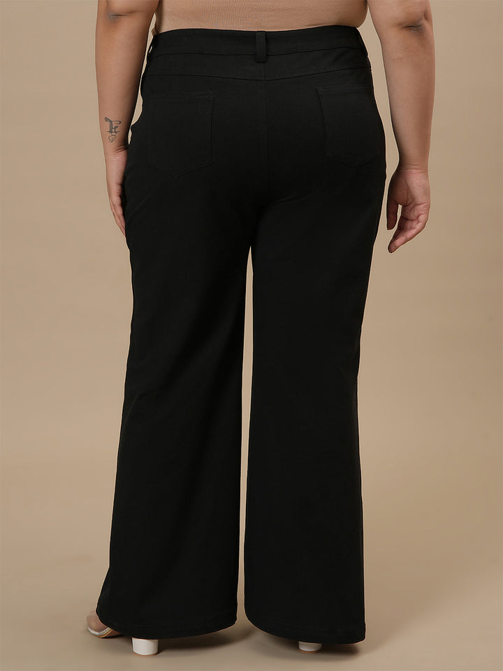 Plus-size woman in back view wearing Black Plus Size Bootcut Jeans with classic pockets and bootcut silhouette