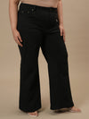 Plus-size woman in front right angle view wearing Black Plus Size Bootcut Jeans with structured fit and flared bottom