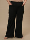 Plus-size woman in front view wearing Black Plus Size Bootcut Jeans with clean front and flared leg