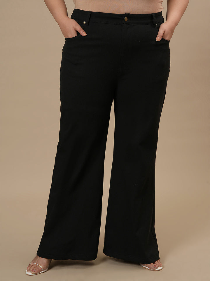 Plus-size woman in front view wearing Black Plus Size Bootcut Jeans with clean front and flared leg