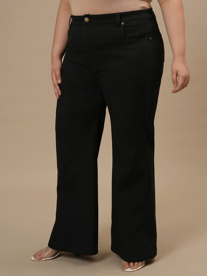 Plus-size woman in left side view wearing Black Plus Size Bootcut Jeans featuring slim fit through thigh and bootcut leg