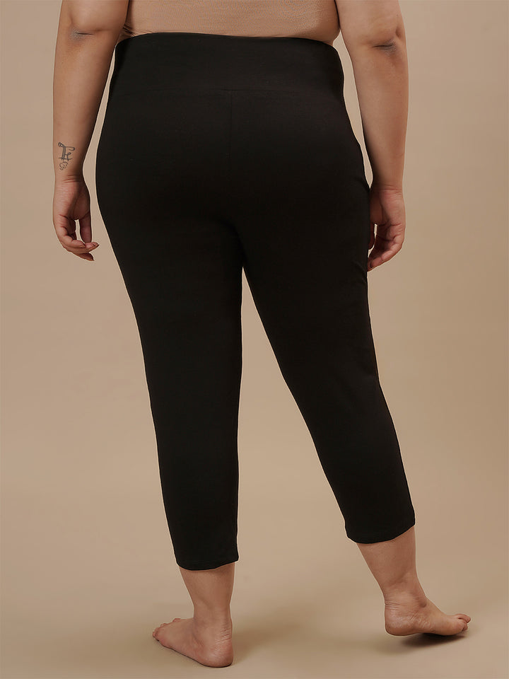 Plus-size woman in back view wearing Black Plus Size Capri Pants with clean back and tapered hem