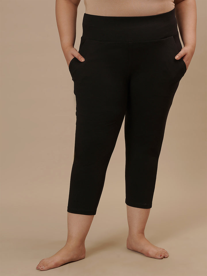 Plus-size woman in front view wearing Black Plus Size Capri Pants featuring slim fit and comfortable fabric