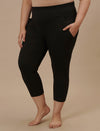 Plus-size woman in left side view wearing Black Plus Size Capri Pants with fitted silhouette and cropped length