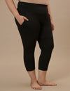 Plus-size woman in right side view wearing Black Plus Size Capri Pants with mid-rise waist and cropped leg design