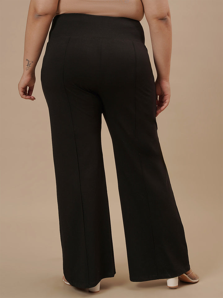 Plus-size woman in back view wearing Black Plus Size Flare Pants featuring flared leg and contoured fit
