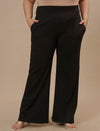 Plus-size woman in front view wearing Black Plus Size Flare Pants with clean front and wide-leg silhouette