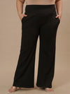 Plus-size woman in front view wearing Black Plus Size Flare Pants with clean front and wide-leg silhouette