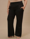 Plus-size woman in side angle view wearing Black Plus Size Flare Pants with flared hem and high-rise fit