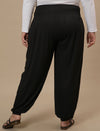 Plus-size woman in back view wearing Black Plus Size Harem Pants with loose fit and comfortable drape