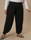 Plus-size woman in front pose wearing Black Plus Size Harem Pants with high waist and slouchy silhouette
