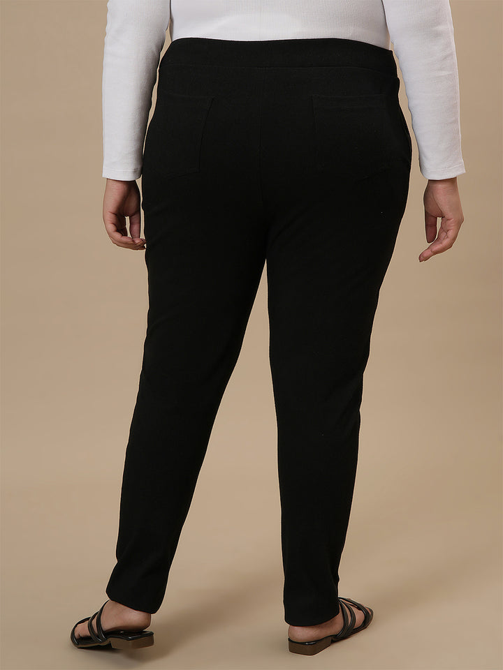 Plus-size woman in back side view wearing Black Plus Size Jeggings with high-rise waist and contoured fit