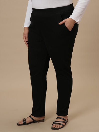 Plus-size woman in front left angle view wearing Black Plus Size Jeggings with high-rise waist and slim fit design