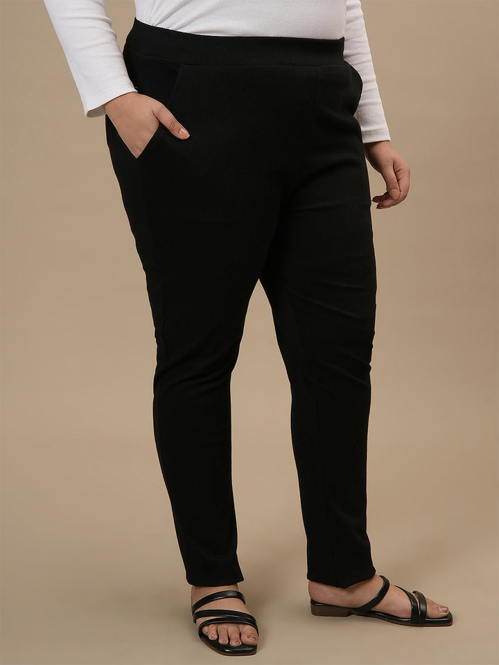 Plus-size woman in front right angle view wearing Black Plus Size Jeggings with high-rise waist and slim fit silhouette