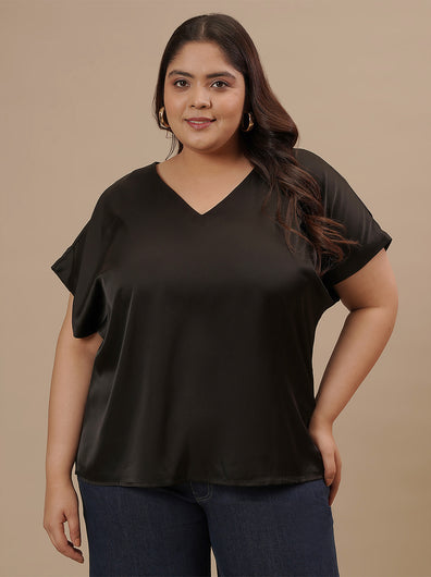 Plus-size woman in front view wearing Black Satin Plus Size Top with relaxed cut and lustrous satin sheen