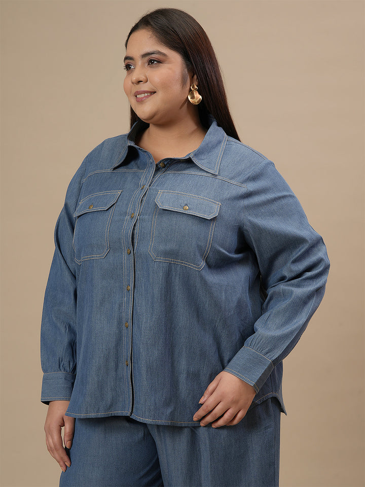 Plus-size woman in left side view wearing Blue Plus Size Denim Shirt featuring full sleeves and classic denim styling