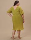 Plus-size woman in back side view wearing Green Pleated Plus Size Formal Dress with pleated skirt and zip back
