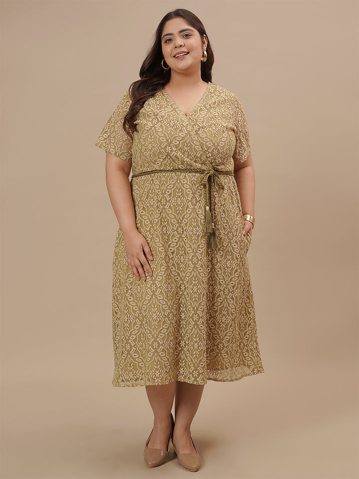 Plus-size woman in front angle view wearing Olive Green Plus Size Lace Dress with floral lace and fitted waist