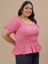 Plus-size woman in front right angle view wearing Pink Plus Size Ruched Fitted Top with ruched front and form-fitting design