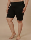 Plus-size woman in left side view wearing Plus Size Cycling Shorts in Black with snug fit and high waist