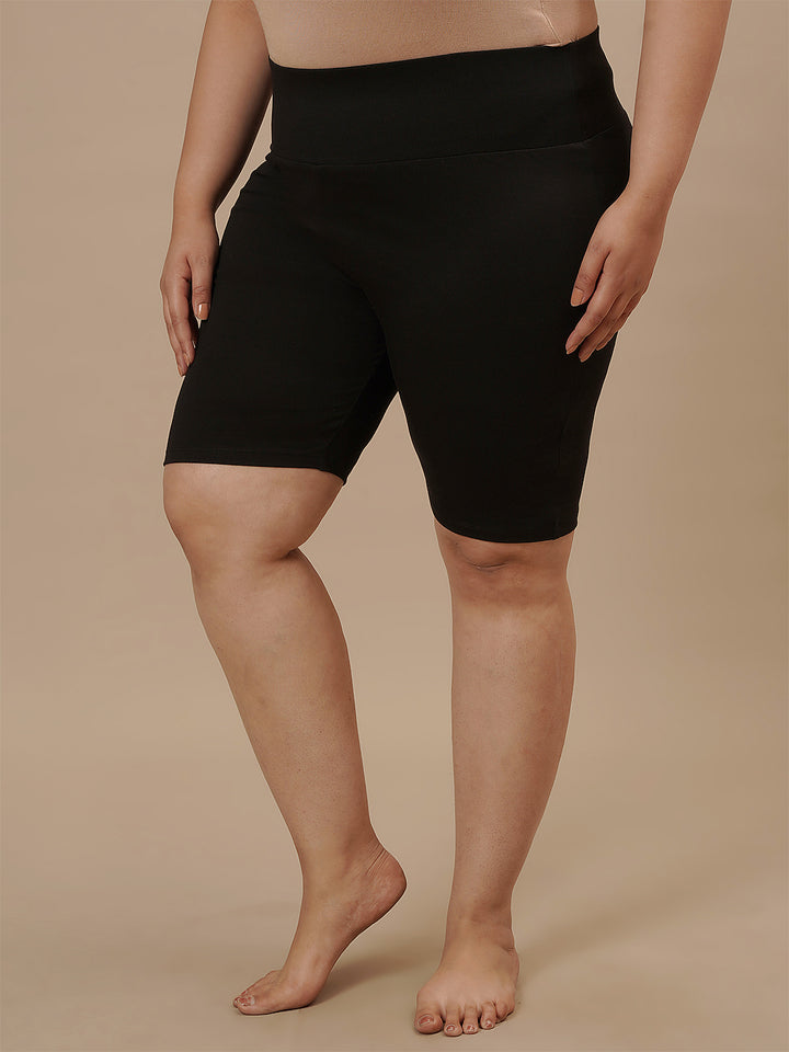 Plus-size woman in left side view wearing Plus Size Cycling Shorts in Black with snug fit and high waist
