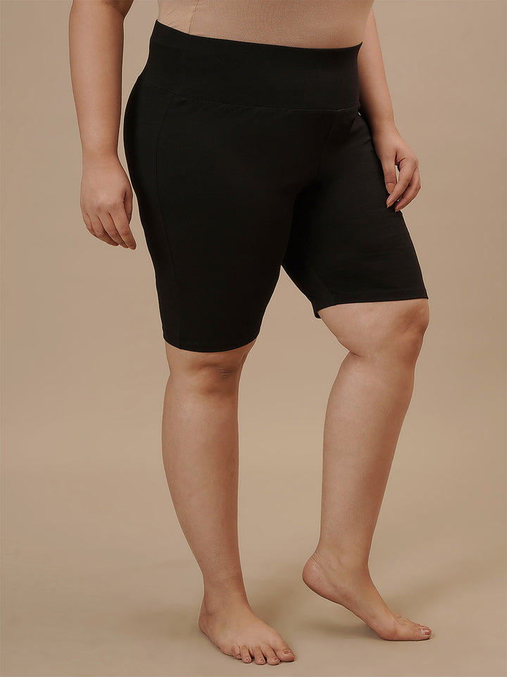 Plus-size woman in right side view wearing Plus Size Cycling Shorts in Black with stretchy fit and sleek design