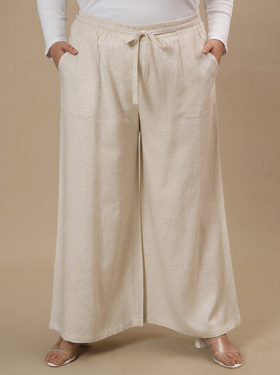 Plus-size woman in front view wearing Plus Size Linen Palazzo Pants in beige featuring flowy fit and elastic waistband