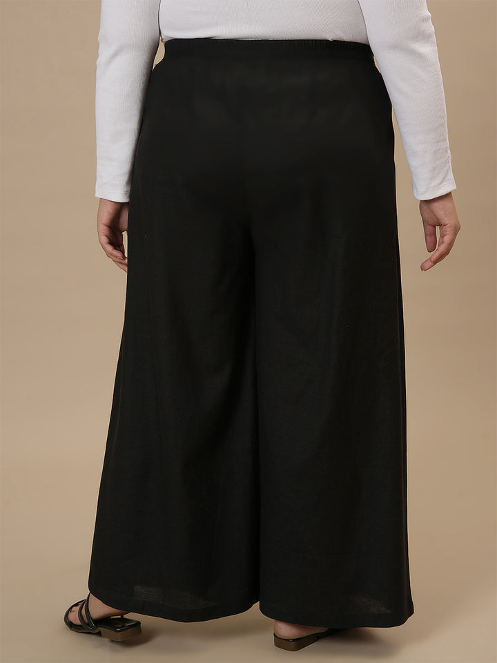 Plus-size woman in back side view wearing Black Plus Size Linen Palazzo Pants with relaxed back and wide leg