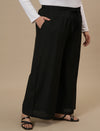 Plus-size woman in front right angle view wearing Black Plus Size Linen Palazzo Pants with flowy wide-leg design