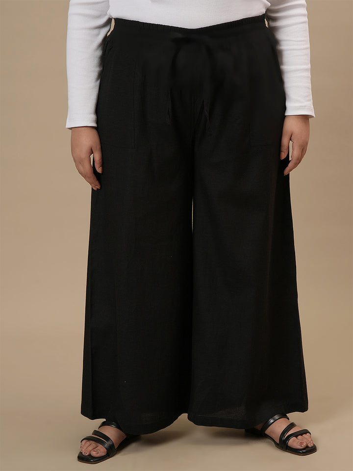 Plus-size woman in front view wearing Black Plus Size Linen Palazzo Pants with wide-leg fit and high-rise waist