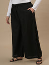 Plus-size woman in left side view wearing Black Plus Size Linen Palazzo Pants with relaxed fit and airy fabric
