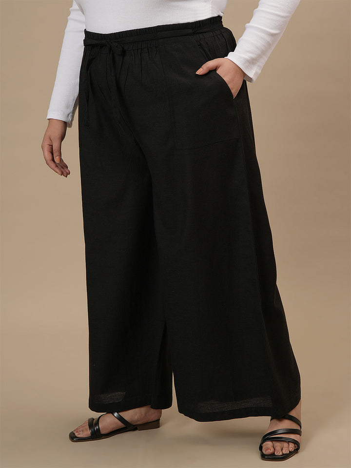 Plus-size woman in left side view wearing Black Plus Size Linen Palazzo Pants with relaxed fit and airy fabric