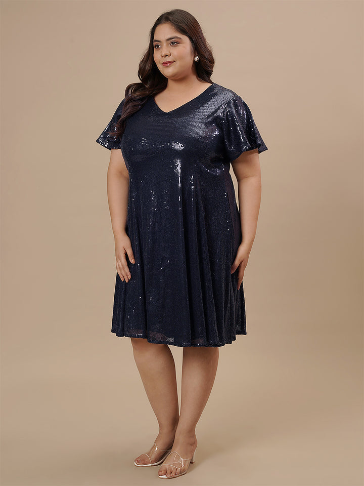 Plus-size woman in side angle wearing Plus Size Sequin Blue Dress featuring sequin texture and fitted shape