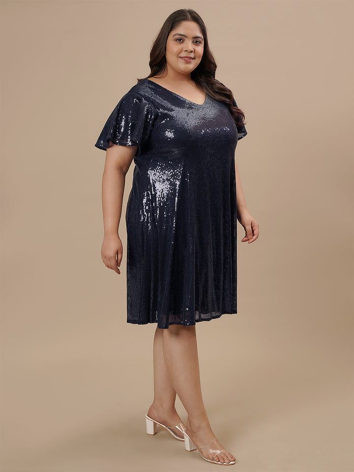Plus-size woman walking in Plus Size Sequin Blue Dress with sleeveless design and sparkling blue sequins