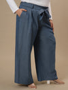 Plus-size woman in side pose wearing Plus Size Wide Leg Jeans in blue with high-rise waist and relaxed wide-leg fit