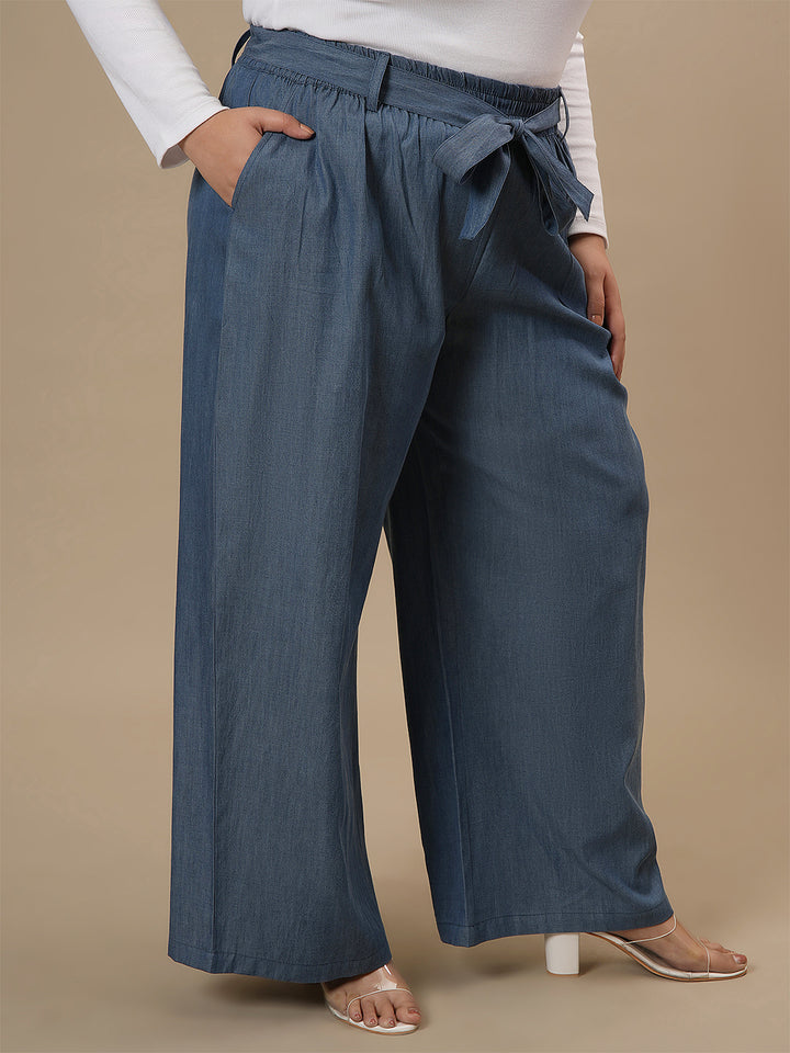 Plus-size woman in side pose wearing Plus Size Wide Leg Jeans in blue with high-rise waist and relaxed wide-leg fit