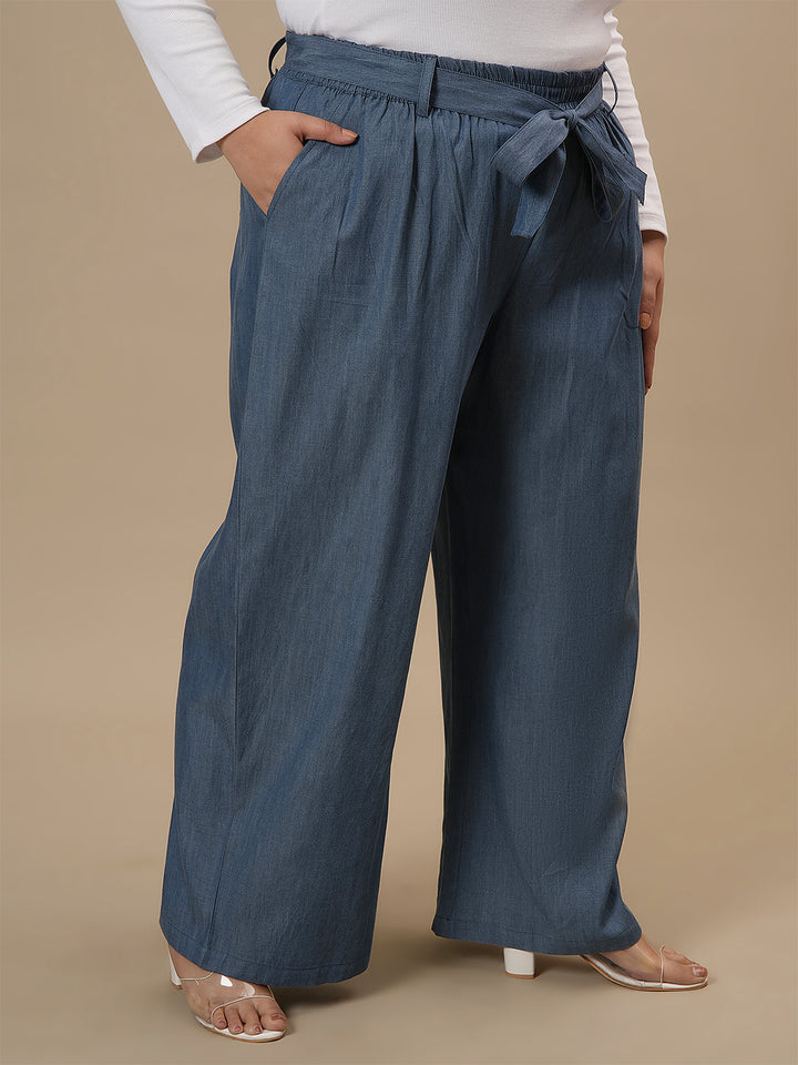 Plus-size woman in side view wearing Plus Size Wide Leg Jeans in blue featuring flowy leg design and structured fit