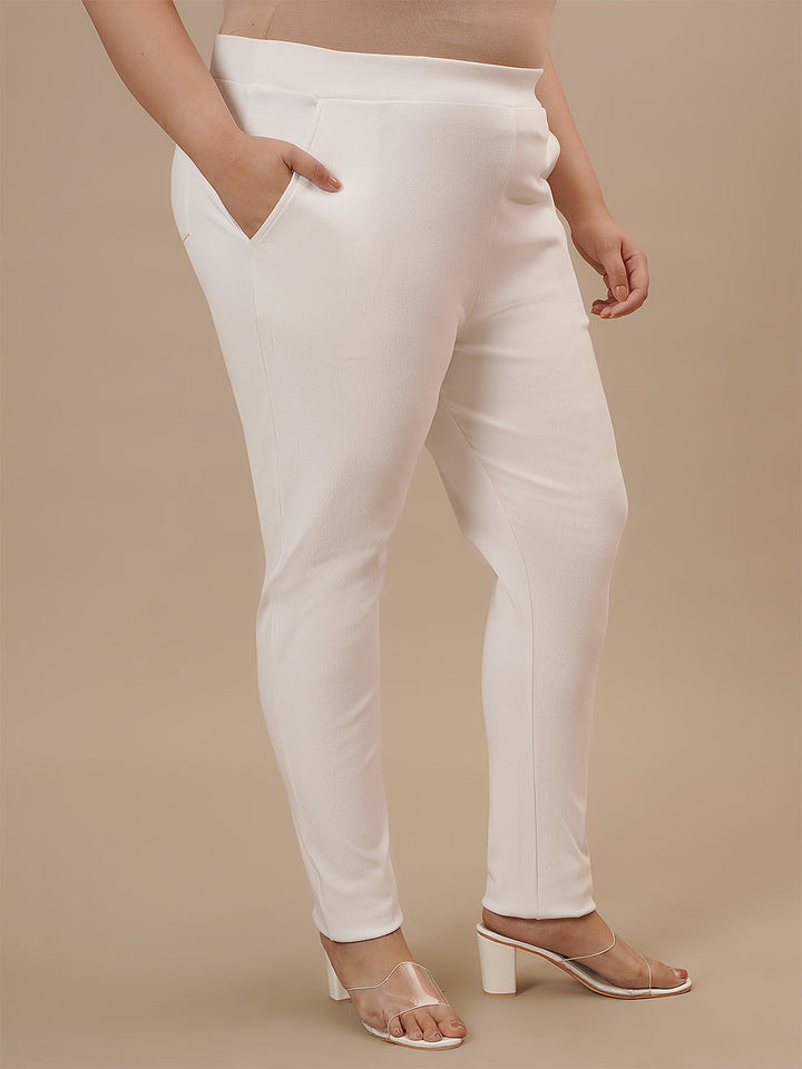 Plus-size woman in side angle view wearing White Plus Size Jeggings with fitted leg and clean silhouette